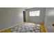 Bright bedroom featuring light gray walls, wood floors, and natural light from the window at 8623 Stonehedge Way, Hudson, FL 34667