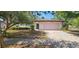 Charming single-story house with lush trees, front yard and a driveway in a residential area at 8623 Stonehedge Way, Hudson, FL 34667