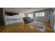 Spacious living room features wood floors and a cozy reading area with a comfortable couch and natural lighting at 8623 Stonehedge Way, Hudson, FL 34667