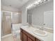 Bright bathroom features a double sink vanity, tiled floor, and glass-enclosed shower at 956 Sombra St, Tampa, FL 33619