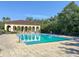 Community pool with crystal clear water, surrounded by lounge chairs and beautiful landscaping at 956 Sombra St, Tampa, FL 33619