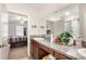 Bright bathroom with dual vanity, granite countertop, and an open view into the main bedroom at 9617 Channing Hill Dr Dr, Ruskin, FL 33573
