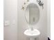 Powder room featuring a pedestal sink, decorative mirror, and butterfly accents at 9617 Channing Hill Dr Dr, Ruskin, FL 33573