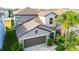 Two-story home with a large driveway and a beautiful, tropical-style landscaped front yard at 9617 Channing Hill Dr Dr, Ruskin, FL 33573