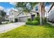 Home with a two-car garage and manicured lawn with a sidewalk leading to the entrance at 9617 Channing Hill Dr Dr, Ruskin, FL 33573