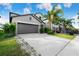 Home with a two-car garage and manicured front lawn with a covered vehicle in the driveway at 9617 Channing Hill Dr Dr, Ruskin, FL 33573