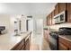 Open kitchen featuring dark wood cabinetry, granite countertops, and a pantry for ample storage at 9617 Channing Hill Dr Dr, Ruskin, FL 33573