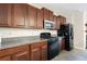 Well-equipped kitchen with stainless steel appliances, granite countertops, and dark wood cabinetry at 9617 Channing Hill Dr Dr, Ruskin, FL 33573