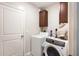 Functional laundry room with white washer and dryer, plus overhead storage cabinets at 9617 Channing Hill Dr Dr, Ruskin, FL 33573