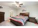 Comfortable bedroom with striped bedding, dark furniture, and a ceiling fan at 9617 Channing Hill Dr Dr, Ruskin, FL 33573