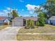 Front exterior of a single-story home with well-manicured lawn and attached garage at 1034 Mandarin Dr, Holiday, FL 34691