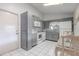 Functional kitchen featuring gray cabinetry, white appliances, and tile flooring offers potential for upgrades at 1034 Mandarin Dr, Holiday, FL 34691
