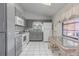 Bright kitchen with grey cabinets, white appliances, and tile flooring at 1034 Mandarin Dr, Holiday, FL 34691