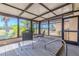 Relaxing enclosed patio with metal chairs and views of tropical greenery at 1034 Mandarin Dr, Holiday, FL 34691