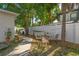 The backyard boasts a tranquil outdoor seating area, complemented by mature trees and a privacy fence at 1050 22Nd N Ave, St Petersburg, FL 33704