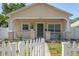 Inviting single-story home with a cozy front porch and a classic white picket fence at 1050 22Nd N Ave, St Petersburg, FL 33704