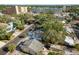 An aerial capture of a neighborhood dotted with homes and abundant foliage, with buildings under construction in the background at 110 Kenwood Ave, Clearwater, FL 33755