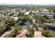 An aerial view showcasing a light blue home with mature trees in a residential area and a partial skyline in the distance at 110 Kenwood Ave, Clearwater, FL 33755