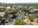 An aerial view showcases a light blue home with mature trees in a residential area and a partial skyline in the distance at 110 Kenwood Ave, Clearwater, FL 33755