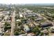 An aerial view showing a residential area and city skyline in the distance, showcasing the light blue home at 110 Kenwood Ave, Clearwater, FL 33755