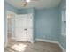 A bright bedroom with light blue walls, baseboards and wood-look floors with a view to the walk-in closet at 110 Kenwood Ave, Clearwater, FL 33755
