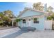Charming light blue home featuring a quaint front yard with tasteful landscaping elements at 110 Kenwood Ave, Clearwater, FL 33755