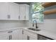 Modern kitchen with white cabinets, stainless steel appliances, and a view from the window for a bright cooking space at 110 Kenwood Ave, Clearwater, FL 33755