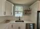 Well-lit kitchen featuring stainless steel appliances, white cabinets, and open shelves for added storage and style at 110 Kenwood Ave, Clearwater, FL 33755