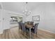 Modern dining room with stylish chandelier, wood floors, and sliding glass doors to the patio at 11218 Sun Tree Rd, Hudson, FL 34667