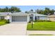 Charming single-story home featuring a screened garage, fresh landscaping and a well-manicured lawn at 11218 Sun Tree Rd, Hudson, FL 34667