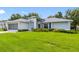 Charming one-story home with fresh landscaping and a spacious green lawn under a blue sky at 11218 Sun Tree Rd, Hudson, FL 34667