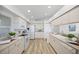 Clean and bright kitchen with modern white appliances, ample counter space, and wood laminate flooring at 11218 Sun Tree Rd, Hudson, FL 34667