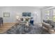 Bright living room featuring modern decor, neutral walls, stylish furniture, and wood flooring at 11218 Sun Tree Rd, Hudson, FL 34667