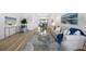 Open-concept living room showcasing hardwood floors, neutral decor, and seamless flow to dining area at 11218 Sun Tree Rd, Hudson, FL 34667