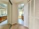 Hallway leading to the bathroom, showcasing dual sinks, and a large closet with sliding doors at 114 Clays Trl # 114, Oldsmar, FL 34677