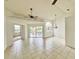 Spacious living room with neutral tile flooring, ceiling fans, and sliding door access to outdoor space at 114 Clays Trl # 114, Oldsmar, FL 34677