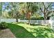 Expansive backyard featuring a white picket fence, mature trees, and green grass at 11932 Whisper Creek Dr, Riverview, FL 33569