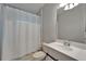 Nicely tiled bathroom with a sink, toilet, shower with white curtain, and white cabinets at 11932 Whisper Creek Dr, Riverview, FL 33569