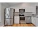 Bright kitchen featuring stainless steel appliances, granite countertops, and sleek white cabinets at 11932 Whisper Creek Dr, Riverview, FL 33569