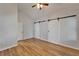 Spacious main bedroom showcasing wood floors and sliding barn doors to closets and bathrooms at 11932 Whisper Creek Dr, Riverview, FL 33569