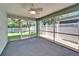 Relaxing screened porch with ceiling fan overlooking white picket fence in the backyard at 11932 Whisper Creek Dr, Riverview, FL 33569