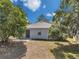 The backyard features a patio with a sliding door, a patch of grass, and mature trees to provide shade at 12351 Ridgedale Dr, Hudson, FL 34669