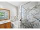 A bathroom features marble countertops, a soaking tub, and a glass shower at 12351 Ridgedale Dr, Hudson, FL 34669