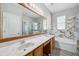 Bright bathroom featuring a double vanity, marble countertops, and a separate tub and glass-enclosed shower at 12351 Ridgedale Dr, Hudson, FL 34669