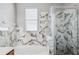 A bathroom features a bathtub and a glass shower with marble accents at 12351 Ridgedale Dr, Hudson, FL 34669