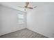 A bright bedroom features wood-look tile floors, neutral walls, and a ceiling fan at 12351 Ridgedale Dr, Hudson, FL 34669
