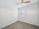 Bright bedroom featuring wood-look tile flooring, ceiling fan, and a window at 12351 Ridgedale Dr, Hudson, FL 34669