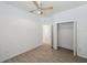 Bright bedroom with wood-look tile flooring, ceiling fan, closet, and hall access at 12351 Ridgedale Dr, Hudson, FL 34669