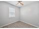 Bright bedroom with wood-look tile flooring, ceiling fan, and a window with blinds at 12351 Ridgedale Dr, Hudson, FL 34669