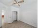 Bright bedroom with wood-look tile flooring, ceiling fan, closet, and view into kitchen at 12351 Ridgedale Dr, Hudson, FL 34669